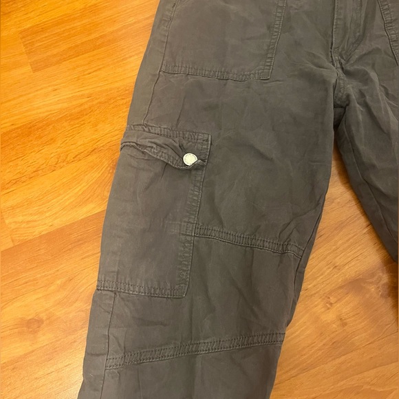 Grey cargos with pockets all over the front of it and visible grey seams. - Picture 3 of 5